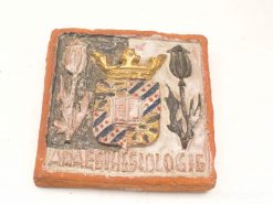 Intricate terracotta ceramic tile featuring heraldic coat of arms and vibrant floral motifs.