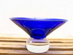 Elegant cobalt blue glass bowl with clear base, perfect for decoration or serving snacks.