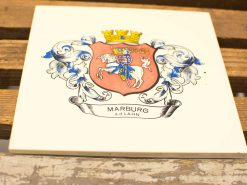 Decorative ceramic tile featuring Marburgs coat of arms with knight, crown, and vibrant colors.