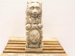 Vintage lion statue with shield, showcasing playful expression and intricate craftsmanship.