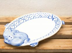 Ceramic oval platter with pig handle and elegant blue pattern, perfect for dining occasions.