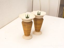 Stylish decorative vases with spiral designs and green holders, perfect for floral arrangements.