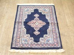 Deep navy vintage rug with floral motifs, elegant medallion, and soft fringes for stylish decor.