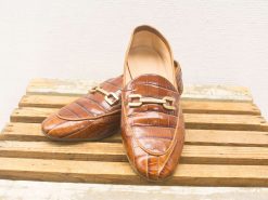 Stylish brown loafers with crocodile texture and gold chain, perfect for versatile fashion choices.