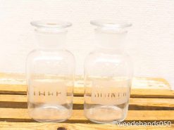 Elegant glass jars for sugar and tea on a rustic wooden surface.