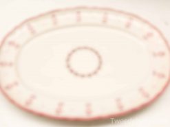 Elegant oval serving platter with soft pink border, perfect for special gatherings and timeless memories.