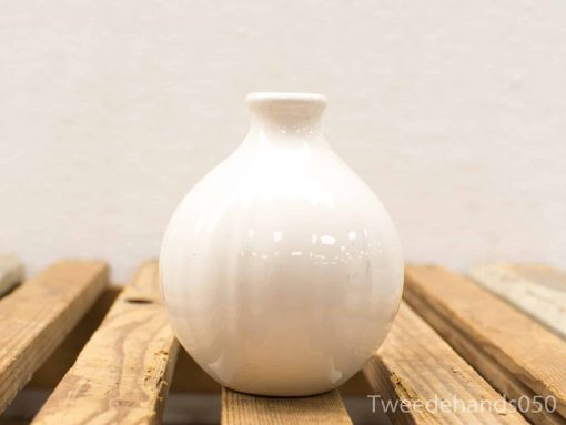 Elegant white ceramic vase on rustic wood, perfect for any decor style.