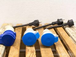 Varied electrical plugs and connectors on rustic wooden surface, perfect for practical uses.