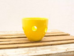 Bright yellow ceramic bowl with unique cut-outs, perfect for decor or candles.