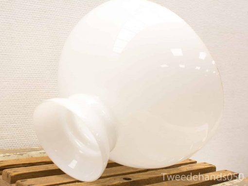 Glossy white vase on rustic wood table, showcasing modern minimalist design elegance.