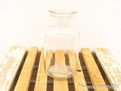 Elegant glass jar on rustic wooden surface for stylish storage and decor.