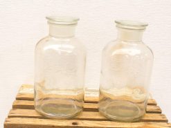 Clear glass jars on a rustic wooden crate, perfect for storage and decor.