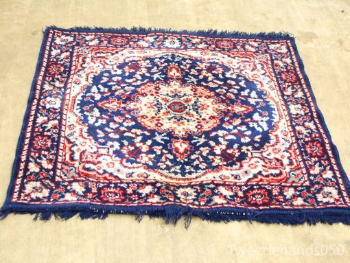 Navy and red handwoven vintage rug with intricate patterns and an ornate medallion design.