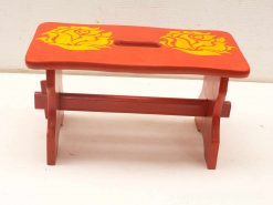 Vibrant red wooden stool with elegant yellow roses, perfect for home decor and functionality.