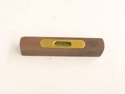 Vintage wooden spirit level with brass vial, showcasing craftsmanship and accuracy for construction projects.