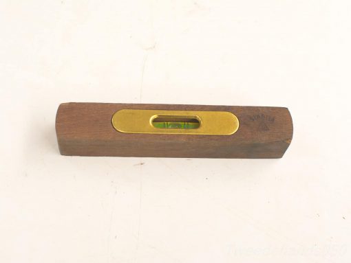 Vintage wooden spirit level with brass vial, showcasing craftsmanship and accuracy for construction projects.