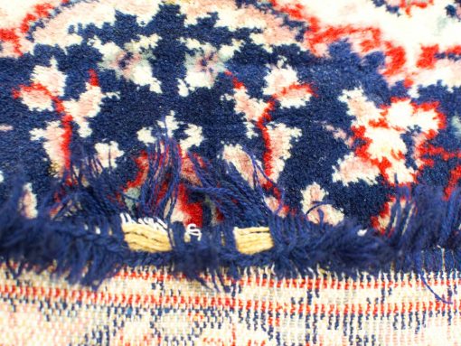 Vintage woven wool tablecloth with rich blue and red patterns and charming fringe details.