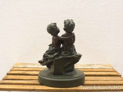 Charming sculpture of two playful children showcasing friendship and innocence in a dark matte finish.