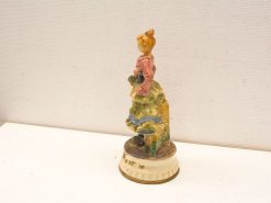 Charming porcelain figurine of a girl holding flowers, vibrant colors, and intricate details.