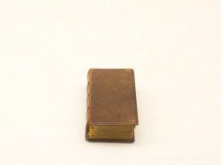 Antique miniature book with leather texture and gold edges, perfect for collectors and decor.