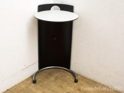 Modern white side table with elegant black base, perfect for stylish interiors.