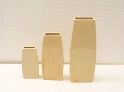 Stylish ceramic vase set in beige, featuring unique textures and varied heights for elegant decor.