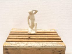 Minimalist white sculpture on rustic crate, embodying elegance and contemplative design.