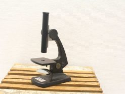 Sleek black microscope on a wooden table, perfect for detailed observations and research.