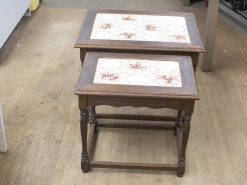 Elegant nesting tables with ceramic tile inlays in rich wood finish for stylish interiors.