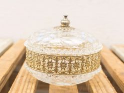 Vintage glass and metal storage container with intricate detailing and elegant design.