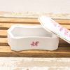 Elegant octagonal porcelain box with pink floral design and gold trim for storing treasures.