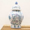 Elegant porcelain urn with lid, featuring delicate lotus flower designs in soft hues.