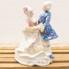 Elegant 18th-century porcelain couple figurine, showcasing timeless romance and intricate craftsmanship.