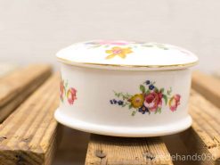 Elegant porcelain trinket box with vibrant floral design, perfect for decor or storing keepsakes.