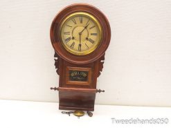 Elegant antique regulator clock with polished wood, Roman numerals, and intricate carvings.