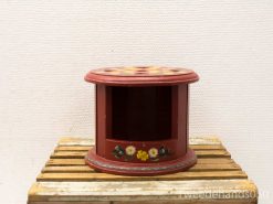 Charming red wooden display stand with hand-painted floral motifs, perfect for showcasing decor.