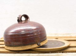 High-quality rustic ceramic serving dish with glossy red-brown lid, perfect for dining experiences.