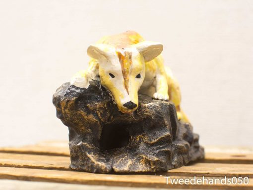 Playful dog sculpture on a rocky base, perfect for vintage home decor.