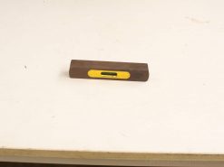 Vintage wooden spirit level with yellow vial for precise measurements in construction and carpentry.