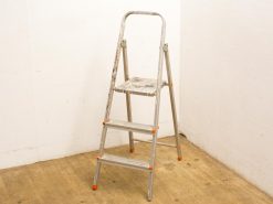 Aluminum step ladder with paint splatters, showcasing vintage style and practical design for home projects.