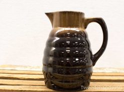 Elegant handmade brown and black ceramic pitcher with unique ridged texture and glossy finish.