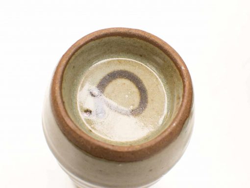 Handcrafted ceramic vessel with unique glaze details and earthy tones, perfect for decor or practical use.