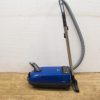 Compact blue vacuum cleaner with user-friendly controls and a flexible hose for easy maneuverability.