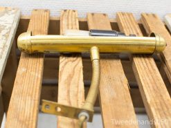 Elegant vintage brass piece with flexible hose, showcased on rustic wooden slats.