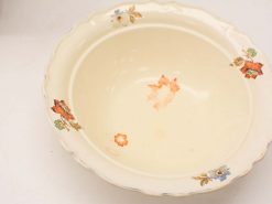 Vintage ceramic bowl with scalloped edges and vibrant floral motifs, perfect for decoration and use.