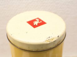 Vintage yellow metal container with whimsical chef logo and charming patina.