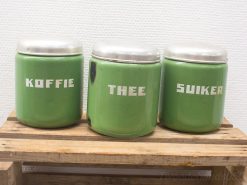 Vintage green jars for coffee, tea, and sugar with metal lids and bold labels.