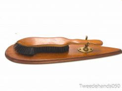 Vintage wooden brush with brass holder, showcasing elegant craftsmanship and timeless grooming charm.