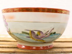 Elegant vintage ceramic bowl with hand-painted cranes and luxurious red and gold accents.