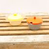 Colorful vintage kitchen bowls on rustic wood, perfect for stylish storage and serving.